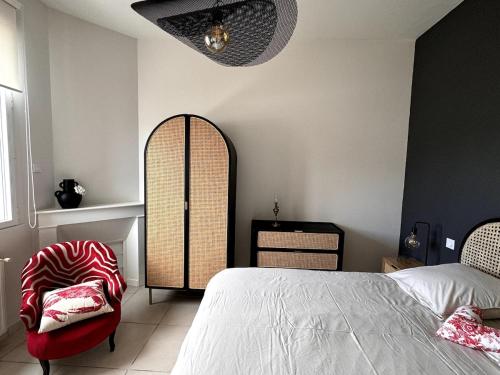 a bedroom with a large bed and a chair at Villa Manolita Andernos les Bains avec jaccuzi in Andernos-les-Bains
