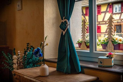 a room with a window with a dress on a table at Gîte Les Sabots de Paille, Alsace Haut-Rhin in Ballersdorf