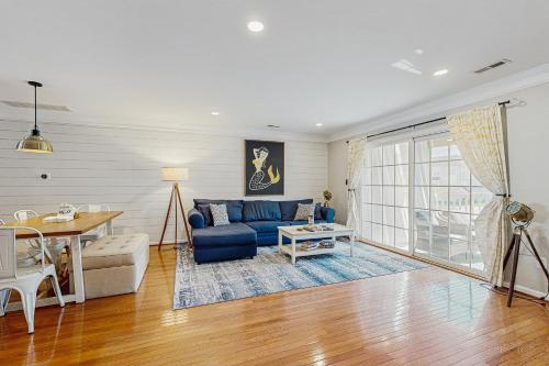 ein Wohnzimmer mit einem blauen Sofa und einem Tisch in der Unterkunft Rehoboth Crossing - 19797 Keystone Dr, Unit 141 in Rehoboth Beach