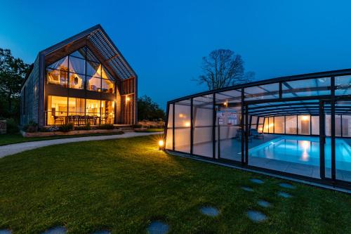 een glazen huis met een zwembad in de tuin bij Villas Goarem Louzet in Tréméoc