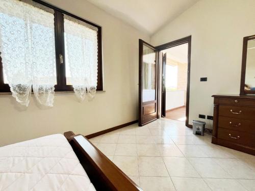 a bedroom with a bed and a dresser and windows at Villa Romea in Guidizzolo