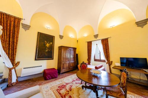 a living room with a table and a tv at Villa Il Fedino in San Casciano in Val di Pesa