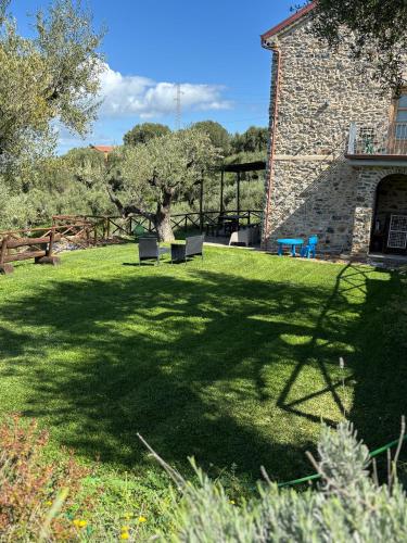 a park with two benches in the shade of a building at Casolare Cento Ulivi Luxury & Charme - Villa exclusive use in Ascea