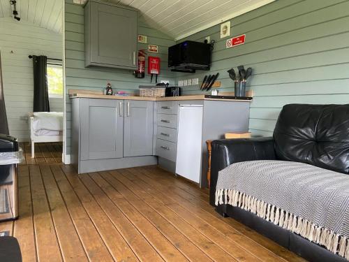 a kitchen with a couch and a counter in a room at Cherry Tree Glamping in Stroud