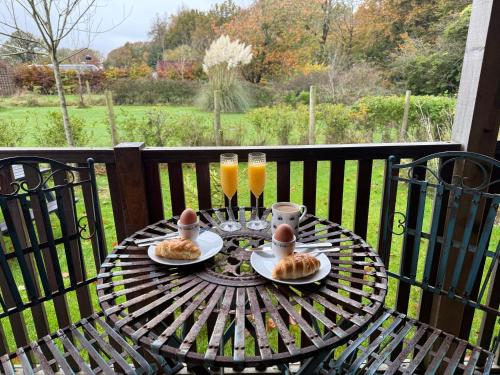 a table with two eggs and two glasses of orange juice at Cherry Tree Glamping in Stroud