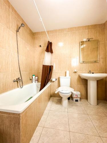 a bathroom with a tub and a toilet and a sink at Apartamento Saica by ALÔGA in Corcubión