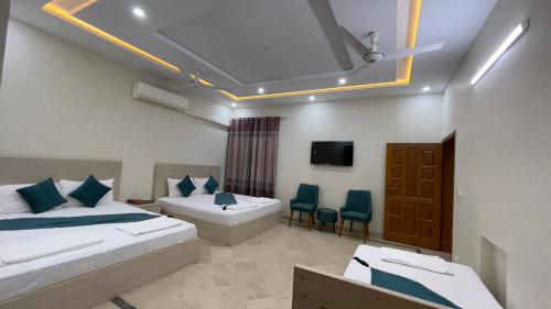 een hotelkamer met 2 bedden en een televisie bij Midways Guest House and Hotels in Islamabad