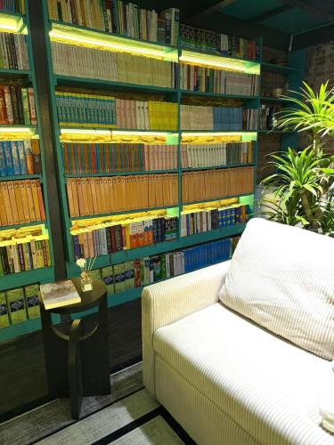 a library with a couch and a table and books at Nhà sách Mão's homestay I in Hanoi