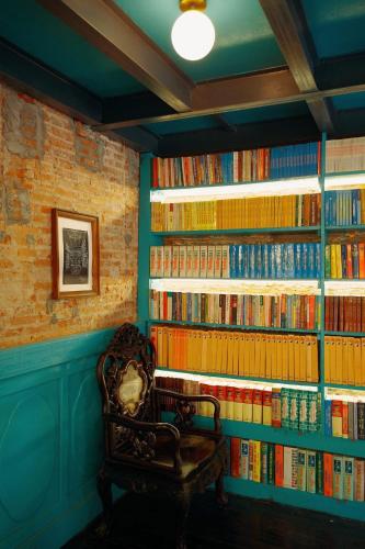 a chair in front of a wall of books at Nhà sách Mão's homestay I in Hanoi