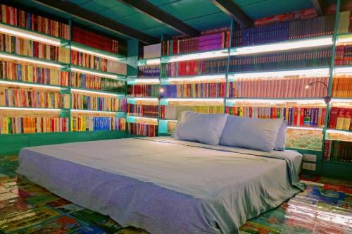 a bedroom with a bed in a room with books at Nhà sách Mão's homestay I in Hanoi
