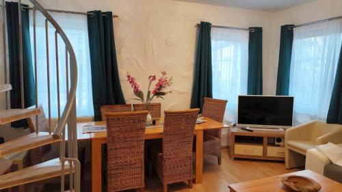 a living room with a table with chairs and a television at City Ferienhaus Vulkaneifel in Daun
