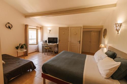 a bedroom with a bed and a desk with a computer at Mas Saint-Ange in Lunel