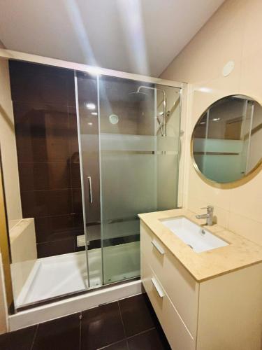 a bathroom with a shower and a sink and a mirror at Vista Gama in Santa Iria da Azóia