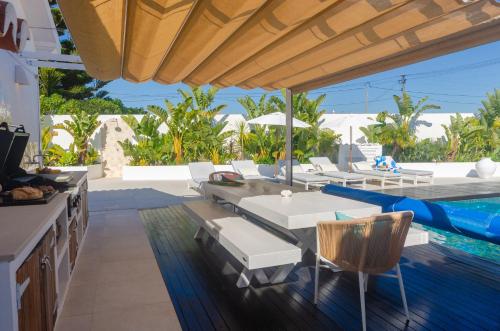 a patio with a table and chairs and a pool at Villa Sound of the Sea by Portugal Collection in Aljezur