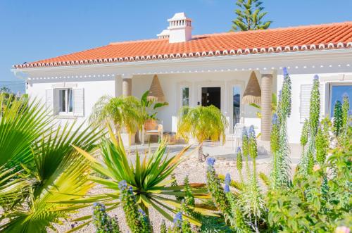 a white house with plants in front of it at Villa Sound of the Sea by Portugal Collection in Aljezur