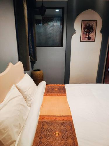 a bedroom with a bed with white sheets and pillows at mstay in Bangkok