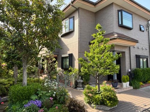 a house with a garden in front of it at S & K Garden House in Tokyo