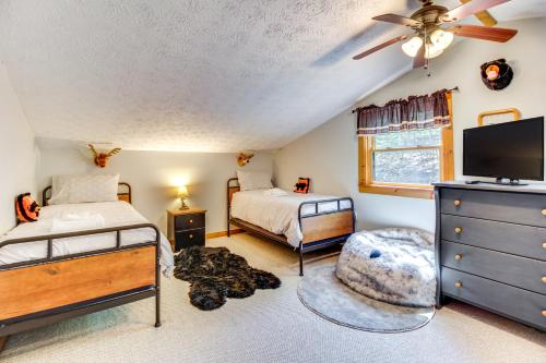 a bedroom with two beds and a flat screen tv at Ellijay Cabin 7 Mi to Dtwn Hot Tub and Mtn Views in Ellijay