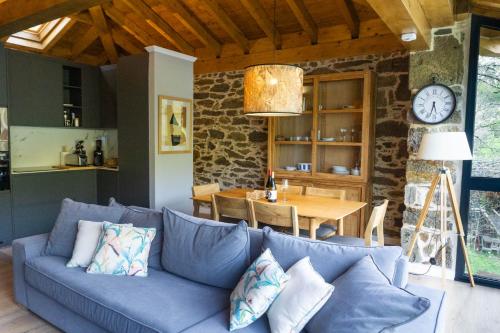 ein Wohnzimmer mit einem blauen Sofa und einem Tisch in der Unterkunft Ribeira Sacra a Orilla Rio Miño Casas do Pincelo in Pincelo