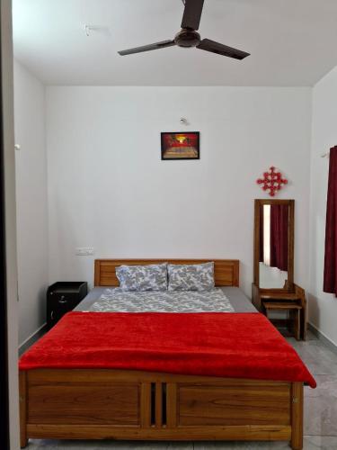 a bedroom with a bed with a red blanket at Ashvis cottage in Thekkady