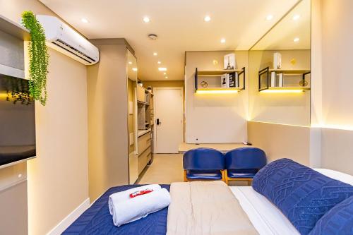 una piccola camera con un letto e due sedie blu di Studio Aconchegante com A/C no All Batel - BAT0821 a Curitiba