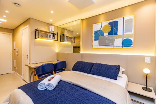 una camera da letto con un letto grande e una scrivania di Studio Aconchegante com A/C no All Batel - BAT0821 a Curitiba