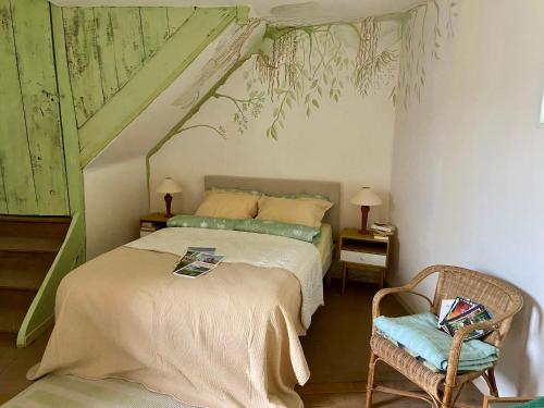 ein Schlafzimmer mit einem Bett und einem Stuhl in der Unterkunft Les ambiances du Coly, La chambre Vézère in Condat-sur-Vézère