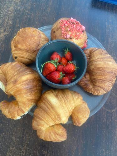 ein Teller mit Croissants und eine Schale Erdbeeren in der Unterkunft Les ambiances du Coly, La chambre Vézère in Condat-sur-Vézère