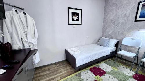 a small room with a bed and a chair at FRОDО - Cozy as a home for 4-6 persons in Tashkent