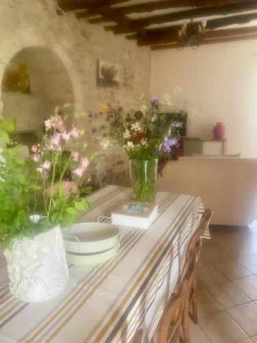 une table avec des fleurs dans des vases au-dessus dans l'établissement Les ambiances du Coly, La chambre Vézère, à Condat-sur-Vézère