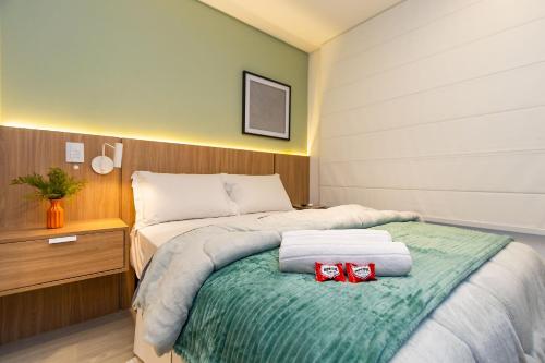 una camera da letto con un letto con due archi rossi sopra di Requinte e Conforto no All Batel - BAT0924 a Curitiba