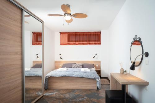 JurdaniにあるHillside Apartmentsのベッドと鏡のある寝室