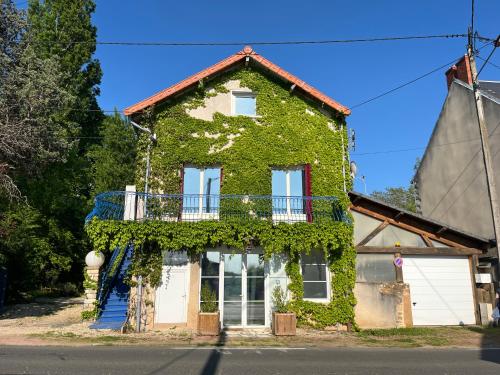 an ivy covered house with a balcony at Couleurs de la vie - Chambres d'Hôtes et Gîte in Cormatin