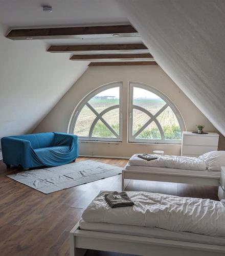 a bedroom with two beds and a large window at Große Landhauswohnung in Ramhusen