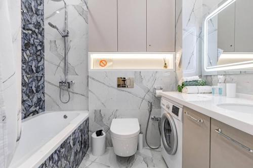 a bathroom with a toilet and a sink and a shower at Mechta in Astana