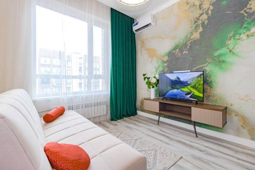 a living room with a white couch and a tv at Mechta in Astana