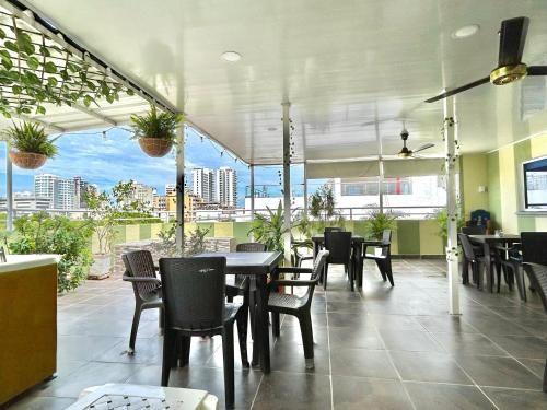 a restaurant with tables and chairs and a large window at Hotel Brisas Del Mar Suite in Santa Marta