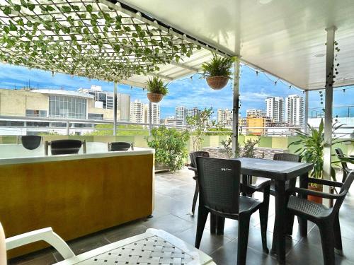 a patio with a table and chairs and a view of a city at Hotel Brisas Del Mar Suite in Santa Marta
