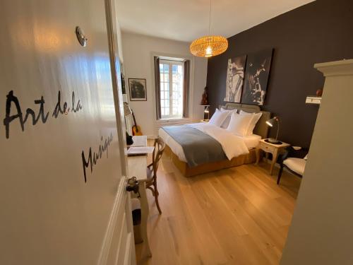 a bedroom with a bed and a table and a chair at La Villa Garenne in Vannes