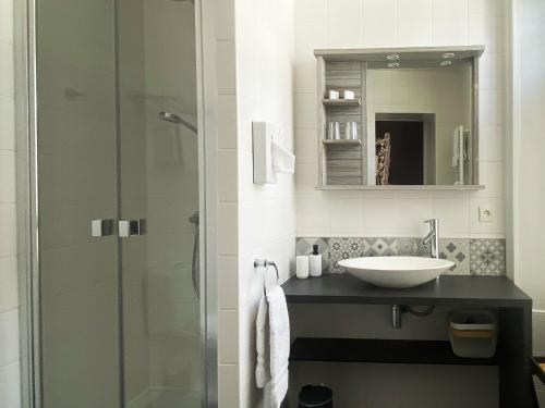 a bathroom with a sink and a glass shower at La Villa Garenne in Vannes