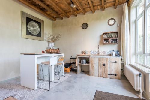a kitchen with a counter and a table in a room at Bed en Breakfast Reijmerstok in Reijmerstok