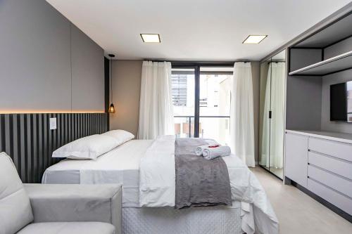 een slaapkamer met 2 bedden, een bank en een tv bij Studio Completo e Refinado no All Batel - BAT1516 in Curitiba