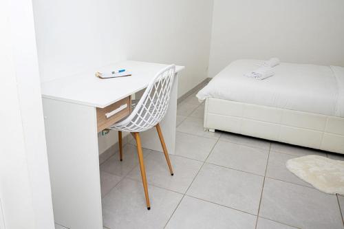 a white desk with a chair next to a bed at L'Elégant aux portes de Genève in Étrembières
