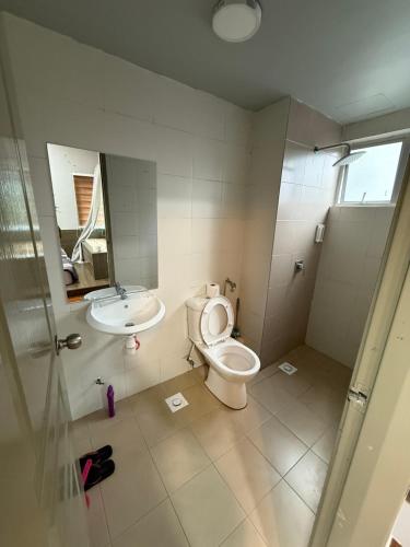 a bathroom with a toilet and a sink at AYAAN Flora Quintet Apartment & Fifa Home 4 with Free Parking in Tanah Rata