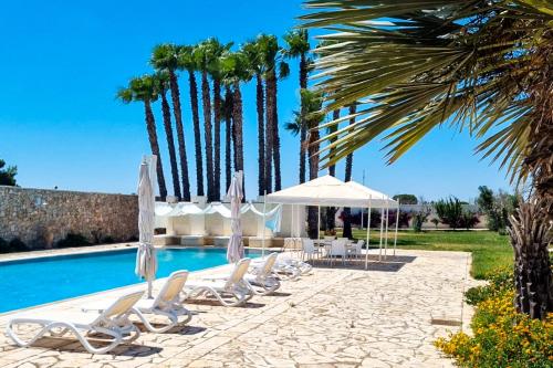 a group of chairs and umbrellas next to a pool at Aqua di Puglia Luxury & Pool - Salento Selection in Nardò