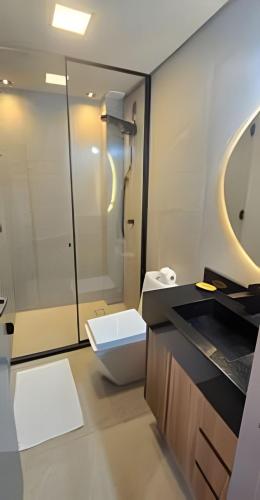 a bathroom with a toilet and a glass shower at City Zen Studios in Sao Jose do Rio Preto