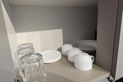 a bathroom with two toilets and plates on a shelf at City Zen Studios in Sao Jose do Rio Preto