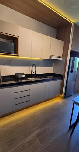 a kitchen with white cabinets and a sink at City Zen Studios in Sao Jose do Rio Preto