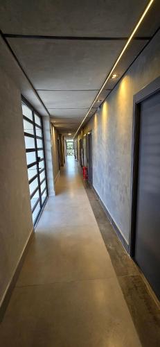 an empty hallway in a building with a long corridor at City Zen Studios in Sao Jose do Rio Preto