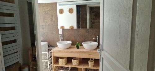 La salle de bains est pourvue de 2 lavabos blancs sur un comptoir en bois. dans l'établissement Domaine le Bouissou Du Mahun Gîtes de groupes en pleine forêt Ardéchoise, à Saint-Symphorien-de-Mahun